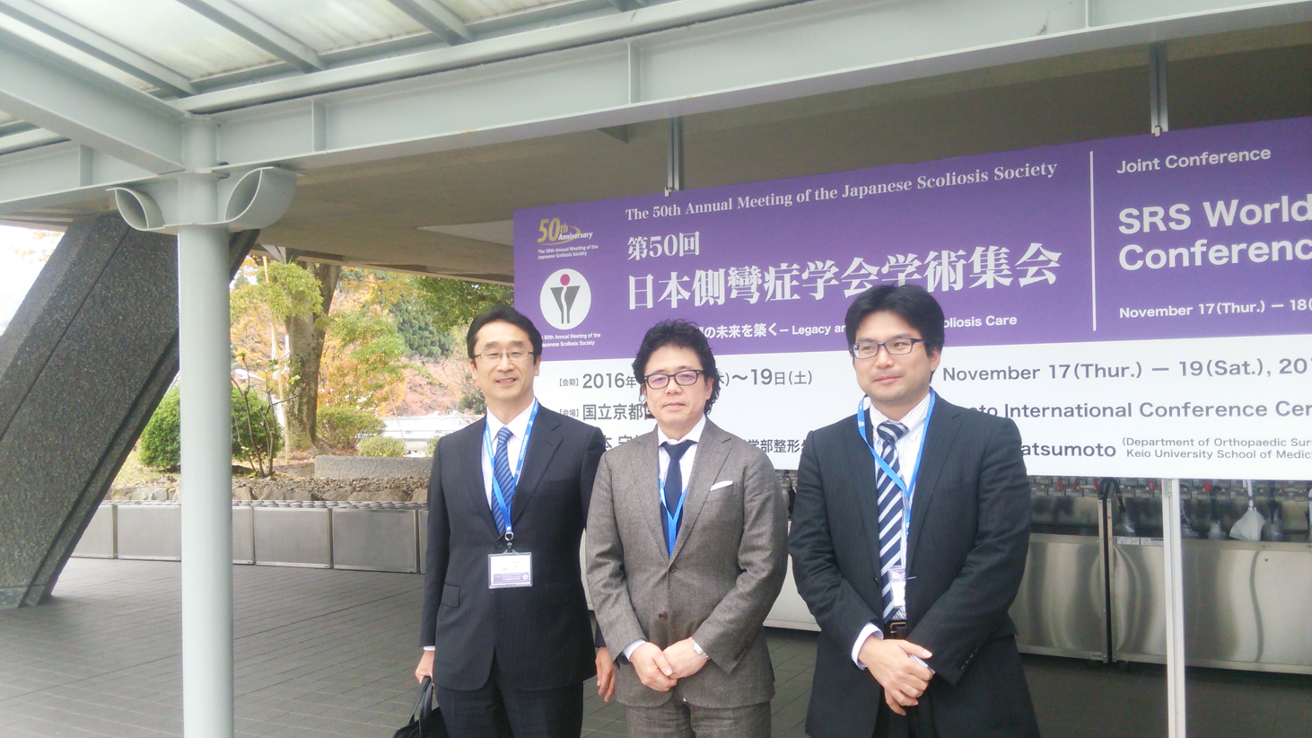 学会場の前で記念撮影 左から、赤澤病院教授、笹生客員教授、飯沼先生